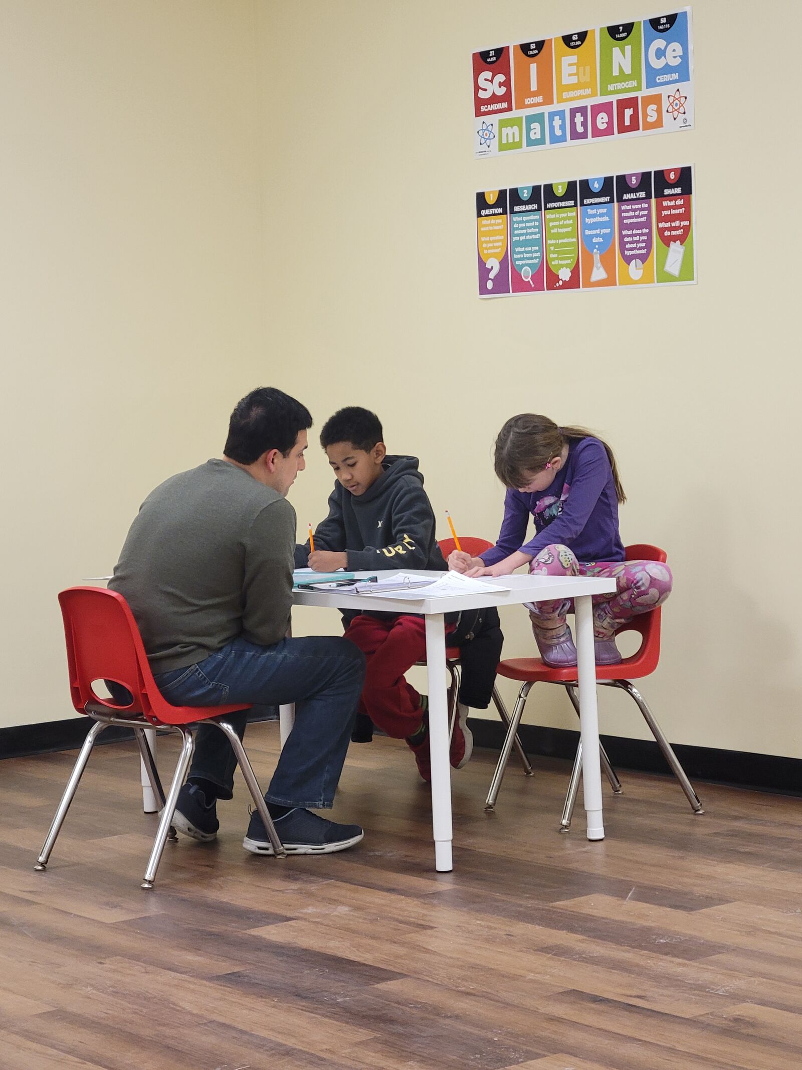 A tutor working with two students on math problems